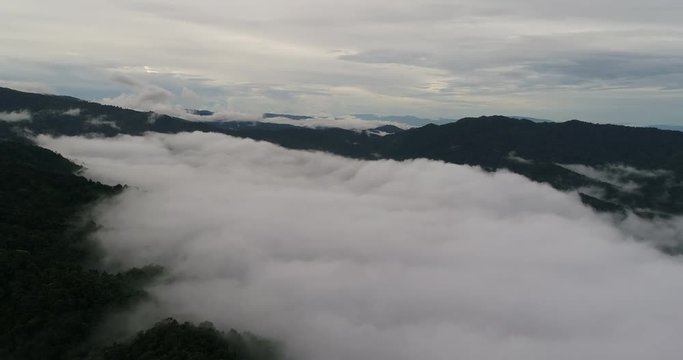 Aerial View. Flying over the beautiful mountain in clouds.