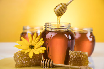Honey jar, flower with dipper and flowing honey