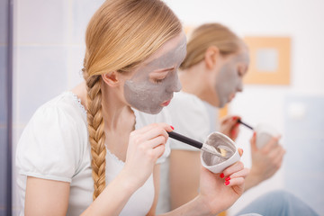 Woman with grey clay mud mask on her face