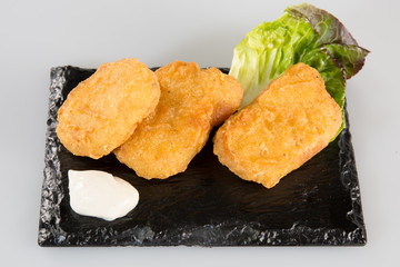 fish fried on a black slate with salad