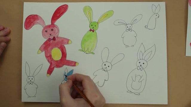 Coloring by watercolor paints of Easter rabbits