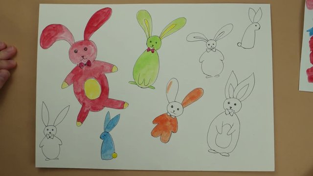 Coloring by watercolor paints of Easter rabbits