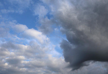 blue sky with black and white clouds