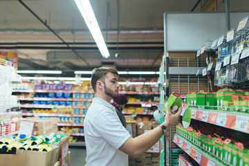 A man chooses goods for a house in a supermarket. Shopping in the store.