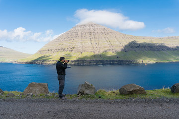 photographer takes a photo of kaldbaksfjordur fiord from a buttercup routes