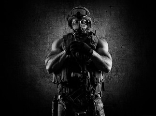 The soldier of the special unit stands with an automatic weapon at the advantage.