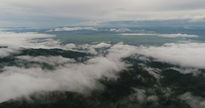 Aerial View. Flying over the beautiful mountain in clouds.