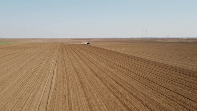 Drone aerial shot of a farmer cultivating arable field