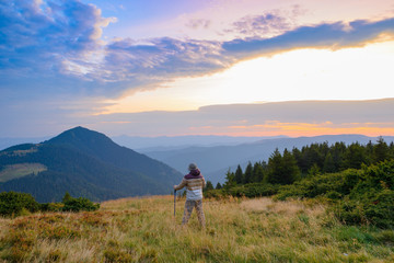 The tourist is watching a spectacular dawn in the Carpathian Mountains.