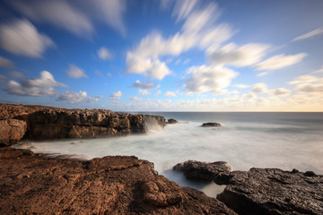 Long exposure from rocks and sea in the Portuguese coastline with the clouds moving