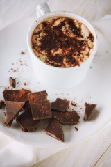 Mug of cocoa and chocolate on a plate