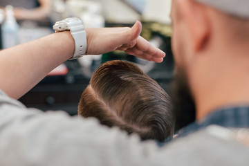 Fototapeta premium A man who shaves a beard with a dangerous razor in a barbercosh.