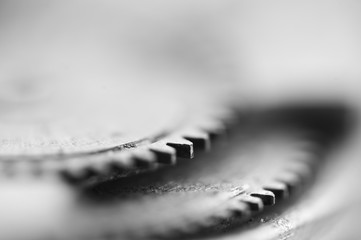 Gear wheels, monochrome industrial background. Very shallow depth of  field, focus is very small. Creative photography for conceptual projects. Macro.