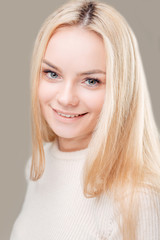Naklejka premium smiling woman with clean skin, natural make-up, and white teeth grey background