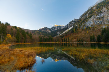 Fototapeta na wymiar Reflection on Lake Frillensee, Inzell, Bavaria, Germany at sunset in fall with Mount Hochstaufen in Background