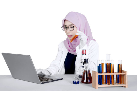 Young researcher using laptop on table