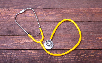 Medical stethoscope and tablets isolated on wooden background