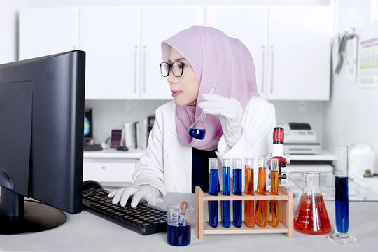 Muslim scientist with test tube and computer
