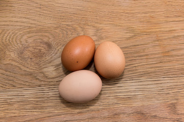 Close-up view of raw chicken eggs  on  oak wooden background