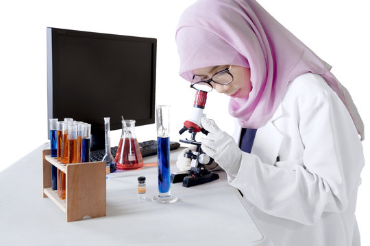 Female researcher looking through a microscope