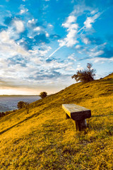 woody bench on top of a hill autumn colors