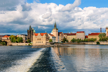 Beautiful view from the river Vltava on the Bank of Prague on a Sunny day with a dramatic sky.