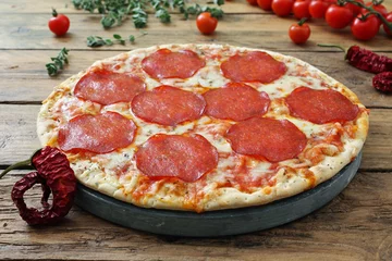 Photo sur Plexiglas Pizzeria pizza salami piccante su sfondo rustico