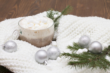 Fototapeta na wymiar delicious hot cocoa with marshmallows on the Christmas table Christmas balls, fir branches knitted scarf warmth and comfort