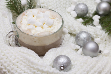 Obraz na płótnie Canvas delicious hot cocoa with marshmallows on the Christmas table Christmas balls, fir branches knitted scarf warmth and comfort
