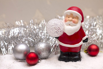 little Santa Claus out in the snow with tinsel and Christmas balls