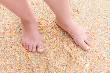 female legs on the sand on the beach view from above