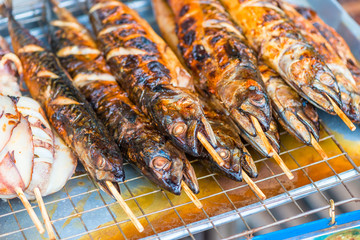 beautiful aromatic grilled fish on skewers close-up - Thai food on the street