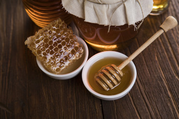 Honey and wooden stick are on a table