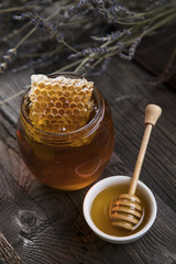 Honey and wooden stick are on a table
