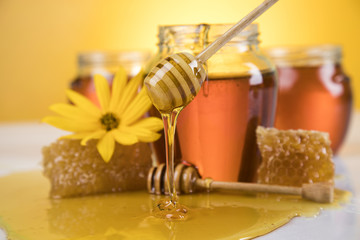 Honey jar, flower with dipper and flowing honey