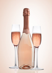 Bottle and glasses of pink rose champagne on pink © DenisMArt