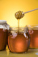 Honey jar, flower with dipper and flowing honey