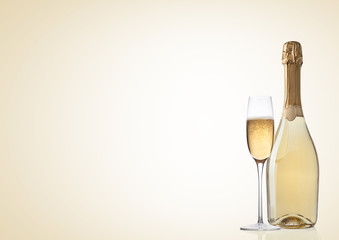 Bottle and glass of yellow champagne on yellow