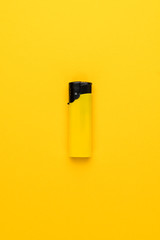 disposable plastic lighter on the yellow background