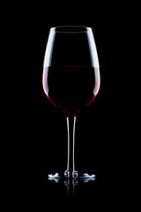 Glass of red wine on black with reflection