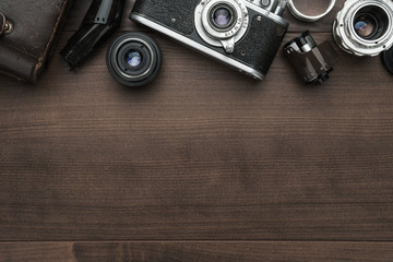 retro film camera and some lenses on the wooden table with copy space