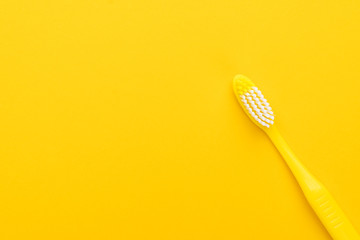 close-up plastic toothbrush on the yellow background