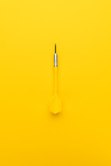 plastic dart with metal tip on the yellow background
