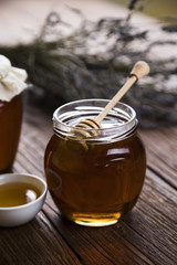 Honey and wooden stick are on a table