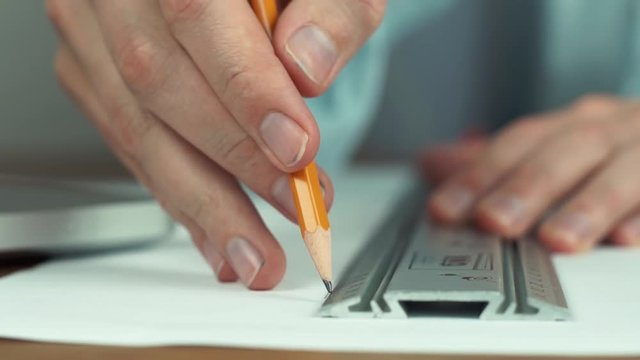 Male hand with pencil. Architect creating housing project, house model on table