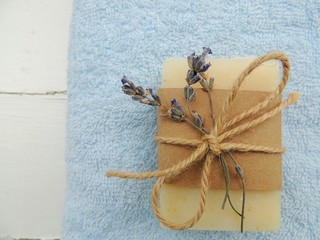 Handmade natural bath spa lavender soap on blue towel, vintage wooden background. Soap making. Soap bars. Spa, skin care.