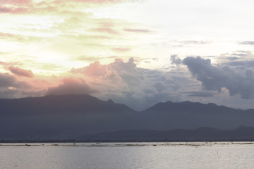 Beautiful sunset over calm lake with cloudy sky and orange sunlight  in Thailand
