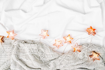 Bedding sheets with fairy lights. Copy space. Flat lay, top view