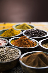 Assortment of spices in wooden bowl background 