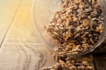 Close-up of muesli spilling from bowl on the wooden table